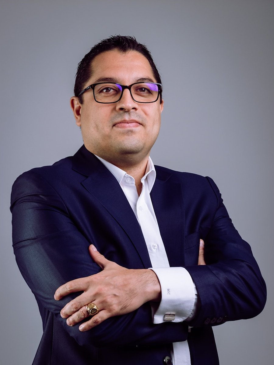 Martin Cabrera Marchán, de terno azul y camisa blanca, con los brazos cruzados, en un retrato de estudio